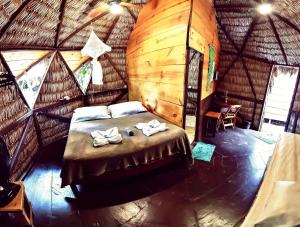 um quarto com uma cama num chalé de madeira em Raiz Kite Cabana em Jericoacoara
