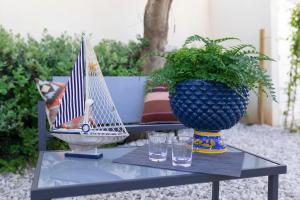 a table with a vase and a toy boat on it at MrBrown - Cinzia Resort Beach in Mazara del Vallo
