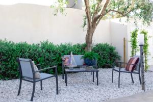 two chairs and a table in a yard with a tree at MrBrown - Cinzia Resort Beach in Mazara del Vallo