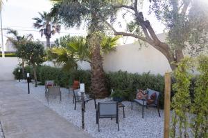 a group of chairs and trees in a courtyard at MrBrown - Cinzia Resort Beach in Mazara del Vallo