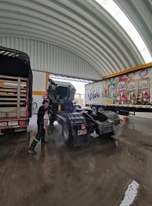 a man is washing a truck in a garage at HOTEL 80 REAL in Tenjo