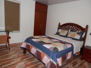 1 dormitorio con 1 cama con edredón en HOTEL 80 REAL, en Tenjo