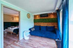 ein Zimmer mit einem blauen Sofa und einem Schlafzimmer in der Unterkunft Marel-Apartments Domek Duna Lux Polanica Zdrój in Polanica-Zdrój