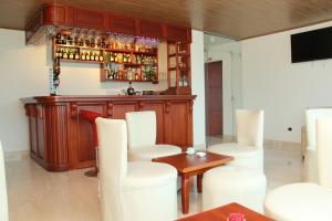 a bar with white chairs and a wooden counter at HOTEL 80 REAL in Tenjo