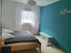a bedroom with a bed and a blue wall at " Die Wolfs Burg" 50qm & zentrumsnah in Wolfsburg