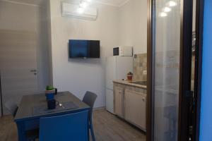 a small kitchen with a table and a refrigerator at MrBrown - Cinzia Resort Beach in Mazara del Vallo