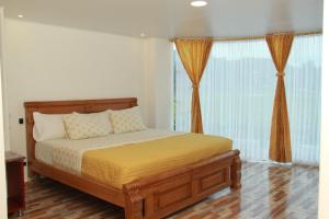 a bedroom with a large bed with orange curtains at HOTEL 80 REAL in Tenjo +73 photos