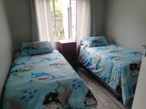 A bed or beds in a room at Charlotte's Web - Beach Cottage - Queensberry Bay