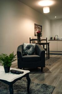 a living room with a chair and a table at Bv Apartments Conditioning House Bradford in Bradford