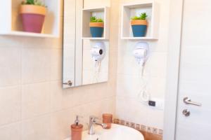 a bathroom with a sink and a mirror and some plants at MrBrown - Cinzia Resort Beach in Mazara del Vallo