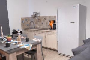 a kitchen with a white refrigerator and a table at MrBrown - Cinzia Resort Beach in Mazara del Vallo