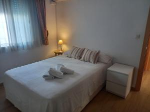 a bedroom with a white bedspread and white pillows at El Viajero en Sevilla in Seville