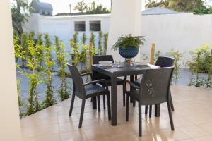 a black table with chairs and a vase on it at MrBrown - Cinzia Resort Beach in Mazara del Vallo