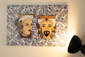 a painting of two heads on a wall at MrBrown - Cinzia Resort Beach in Mazara del Vallo