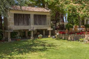 una casa con un patio con sillas y flores en Hotel Spa Bosque Mar, en Reboredo