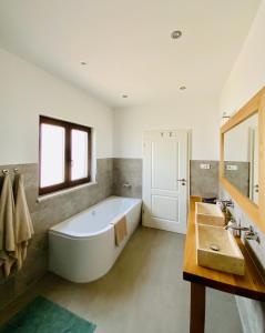 a large bathroom with a tub and a sink at Villa Fluggi near Labin in Santalezi
