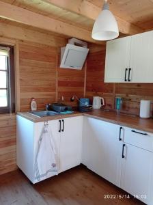 a kitchen with white cabinets and a counter top at Domek nad Potokiem in Szczytna