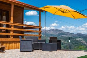 a patio with chairs and a yellow umbrella at Encosta do Sonho in Vieira do Minho