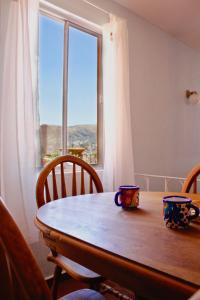 uma mesa de madeira com duas xícaras em cima em Colorful family condo with terrace and free parking em Guanajuato