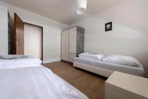 2 Betten in einem Zimmer mit weißen Wänden und Holzböden in der Unterkunft Workers Home- Central - 8 single box spring beds - near Enschede in Gronau