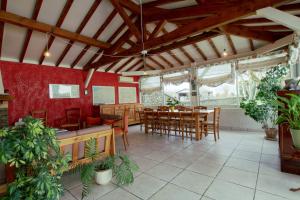 comedor con paredes rojas y mesas y sillas de madera en La Grange de Georges, en Lay-Lamidou