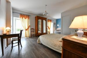 a bedroom with a bed and a desk and a desk at La Grange de Georges in Lay-Lamidou