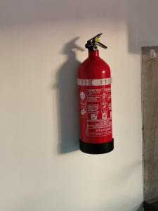 una boca de incendios roja está en una pared en Villaventure, en Le Vauclin