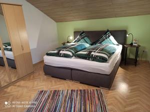 a bedroom with a large bed and a mirror at Ferienhaus Wellisch in Lohberg