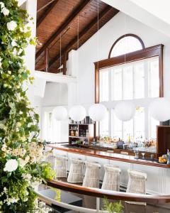 uma sala de jantar com um bar com bancos brancos em EHP Resort & Marina em East Hampton