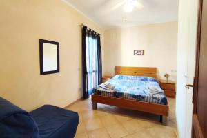 a bedroom with a bed with a blue comforter at Casa Paguro, la Tua casa in Sardegna in Porto San Paolo