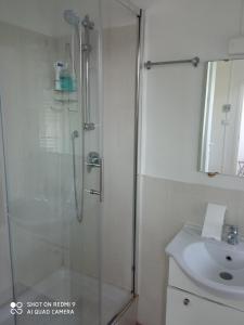 W łazience znajduje się prysznic i umywalka. w obiekcie casa del sole Ossuccio w Como