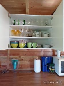 a kitchen with shelves filled with bowls and dishes at Domek nad Potokiem in Szczytna