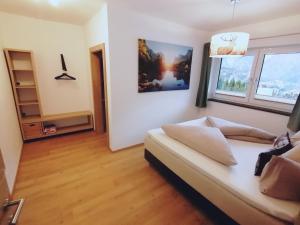 ein Wohnzimmer mit einem Sofa und 2 Fenstern in der Unterkunft Living Apartment Maurer in Sautens