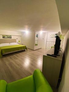 ジャルディーニ・ナクソスにあるNaxos Apartmentsのベッド、ソファ、テレビが備わる客室です。