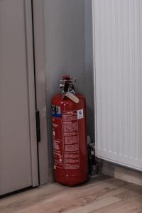 a red fire hydrant sitting next to a door at The Beetle House in Volos