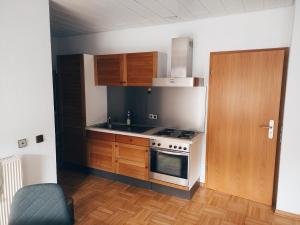a kitchen with wooden cabinets and a stove top oven at Maison Mellie in Oberhausen