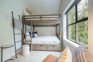 ein Schlafzimmer mit einem Etagenbett und einem Fenster in der Unterkunft Powderview 24 by Outpost Whistler in Whistler