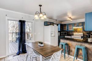 eine Küche mit blauen Schränken sowie einem Tisch und Stühlen in der Unterkunft WOW! Spacious Retreat & amazing yard 2400+4bd/3bth in Wichita