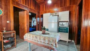 a kitchen with a table and a refrigerator at Piscina Aquecida , SPA, Bilhar, Churrasqueira, Wi-Fi in Itanhaém