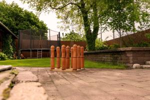 a row of orange fire hydrants in a yard at Fazekasház in Nagykáta