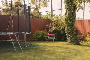 un columpio en un patio junto a un árbol en Fazekasház en Nagykáta