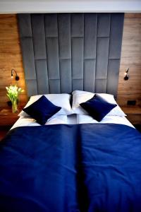 een bed met blauwe en witte lakens en kussens bij Apartament Anna in Bachowice
