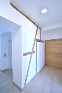 ein leeres Zimmer mit einem großen Fenster und einer Holztür in der Unterkunft Appartement-Hotel GH Zum Goldenen Schiff in Enns