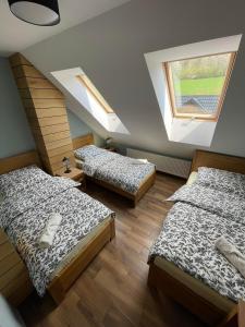 two beds in a room with two windows at Bacówka Polany in Polany