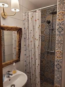 a bathroom with a shower curtain and a sink at Uroczysko Skomackie in Stare Juchy