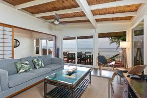 a living room with a couch and a table at Waimea Bay Shoreline House in Haleiwa