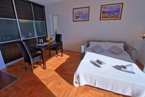 uma sala de estar com uma cama, uma mesa e um sofá em Studio Apartman LUKA em Senj