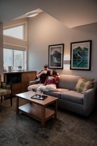 un hombre y una mujer sentados en un sofá en una sala de estar en Mount Robson Inn en Jasper