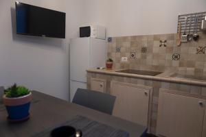 a small kitchen with a table and a refrigerator at MrBrown - Cinzia Resort Beach in Mazara del Vallo