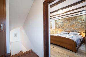 a bedroom with a bed and a stone wall at Boutique House Rustikana by Locap Group in Izola